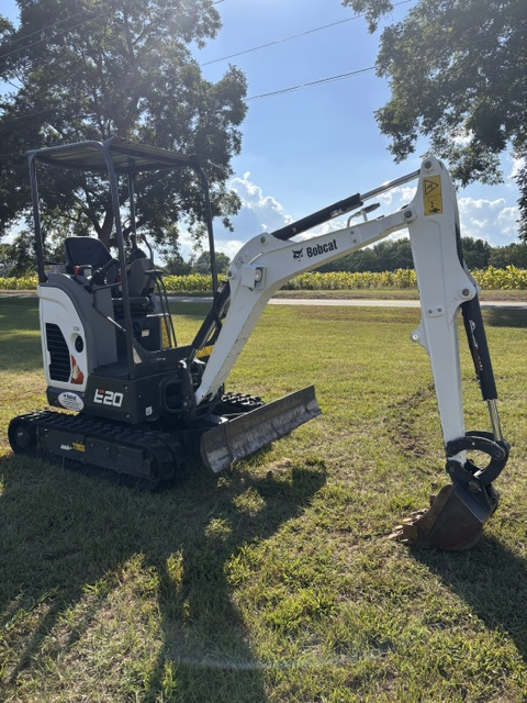 Bobcat E20 mini excavator front angle view in a field